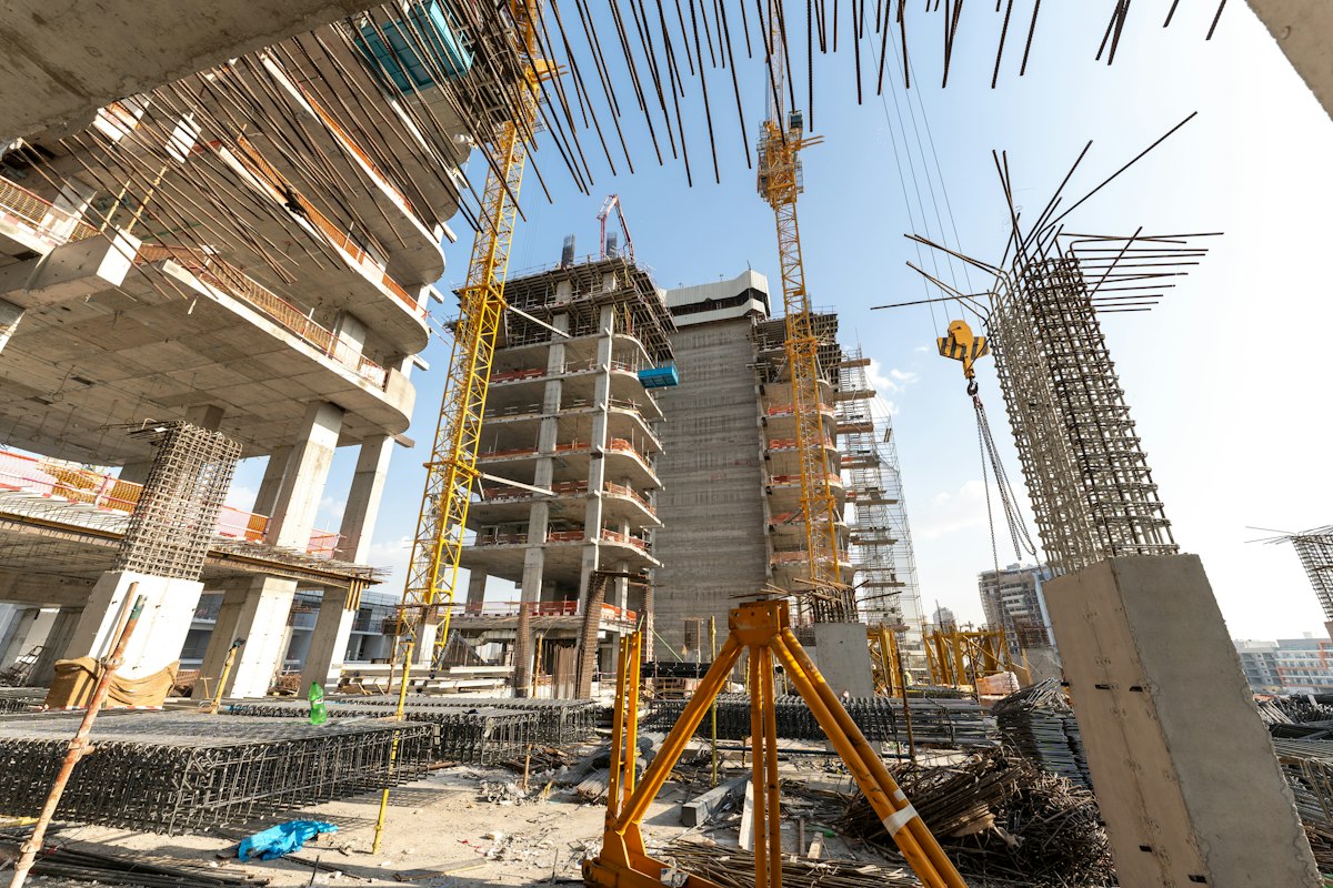 Illustrative construction site showing reinforced concrete structures and site surveying equipment